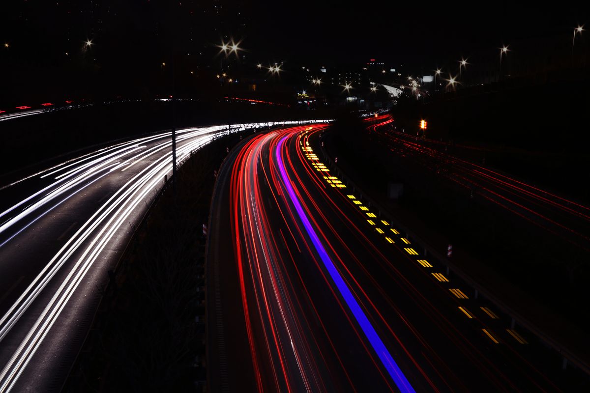 Long-exposure light trails from highway traffic at night